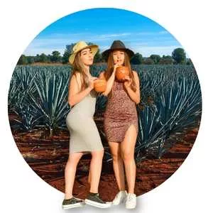 dos mujeres tomandose un cantarito de tequila frente a los campos agaveros de Tequila Jalisco