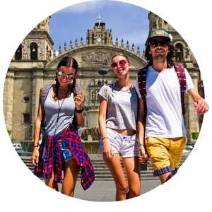 dos mujeres y un hombre caminando frente a la catedral de guadalajara